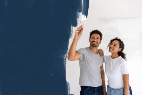 happy couple painting their house - home decoration stock pictures, royalty-free photos & images