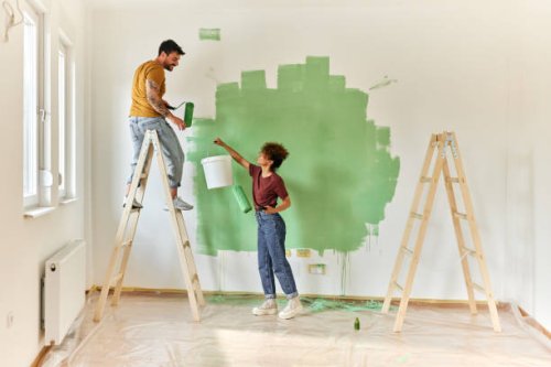 happy couple painting their new apartment. - home decoration stock pictures, royalty-free photos & images