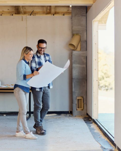 happy couple reading blueprints of their developing house. - home decoration stock pictures, royalty-free photos & images
