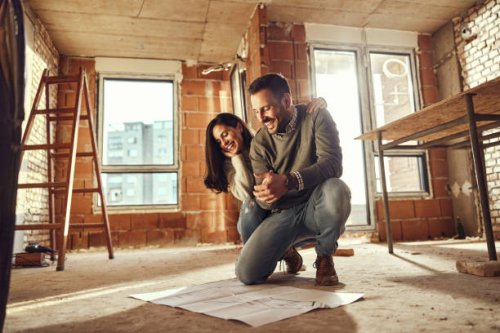 happy couple reading plans at their renovating apartment. - home decoration stock pictures, royalty-free photos & images