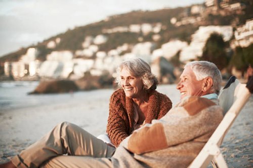 happy couple relaxing on chairs at beach - travel photos et images de collection