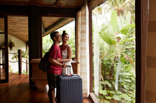 happy couple standing near window at villa - travel stock pictures, royalty-free photos & images