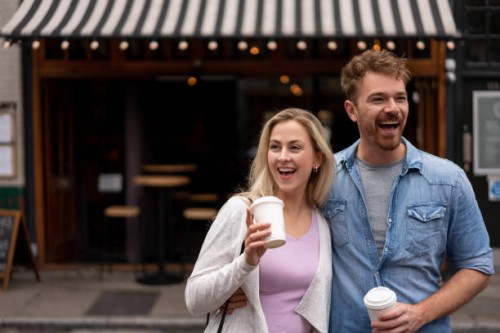 happy couple taking a cup of coffee on-the-go - junk food stock pictures, royalty-free photos & images