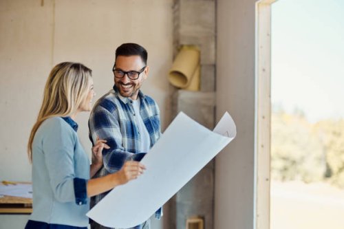 happy couple talking about blueprints of their developing house. - home decoration stock pictures, royalty-free photos & images