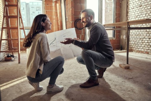 happy couple talking about plans at their renovating apartment. - home decoration stock pictures, royalty-free photos & images