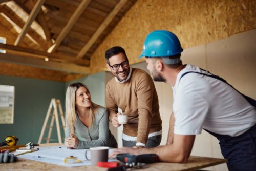 happy couple talking to manual worker at construction site. - home decoration stock pictures, royalty-free photos & images