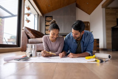 happy couple working on a home addition project and sketching some blueprints - home decoration stock pictures, royalty-free photos & images