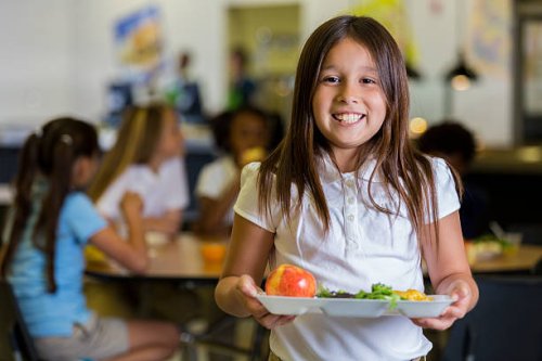 happy elementary school girl with healthy food in cafeteria - food stock pictures, royalty-free photos & images