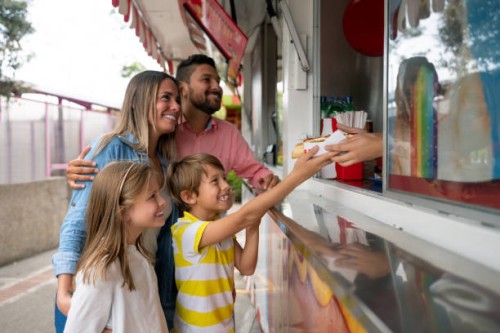 happy family buying food at an amusement park - food stock pictures, royalty-free photos & images