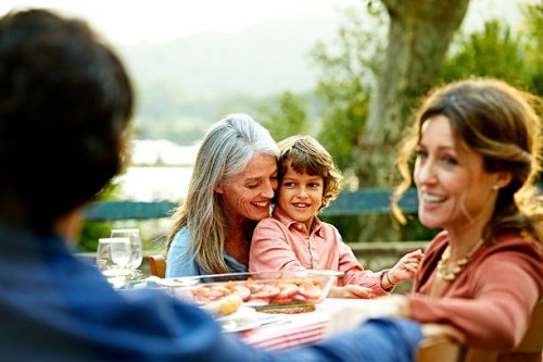 happy family sitting at outdoor meal table - garden decoration photos et images de collection