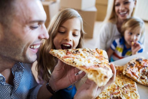 happy father and daughter eating pizza for lunch after moving into new home. - junk food stock pictures, royalty-free photos & images