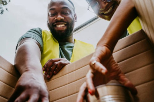 happy female and male heroes arranging canned foods in box - food stock pictures, royalty-free photos & images