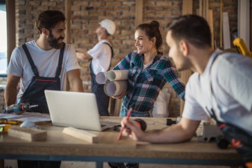 happy female architect talking to construction workers during home renovation process. - home decoration stock pictures, royalty-free photos & images