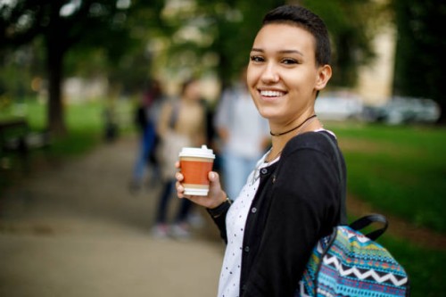 happy female college student outdoors - junk food stock pictures, royalty-free photos & images