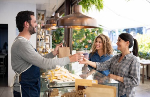 happy female friends buying take out food at a coffee shop - junk food stock pictures, royalty-free photos & images