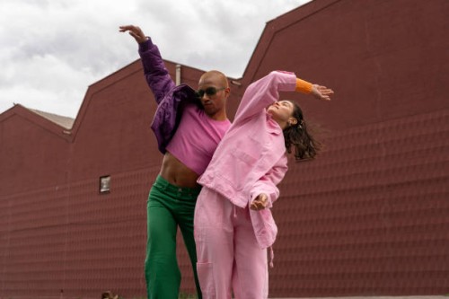 happy friends dancing together in front of building - fashion stock pictures, royalty-free photos & images