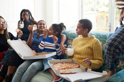 happy friends enjoying slumber party with pizza and juice - junk food stock pictures, royalty-free photos & images