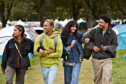 happy friends walking arm in arm at campsite - concert stock pictures, royalty-free photos & images