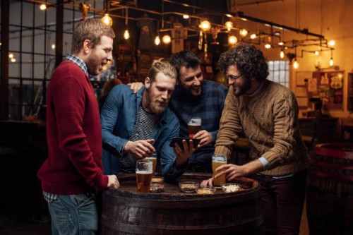 happy gatherings at the pub: group of happy young men taking a selfie while drinking beer - home decoration stock pictures, royalty-free photos & images