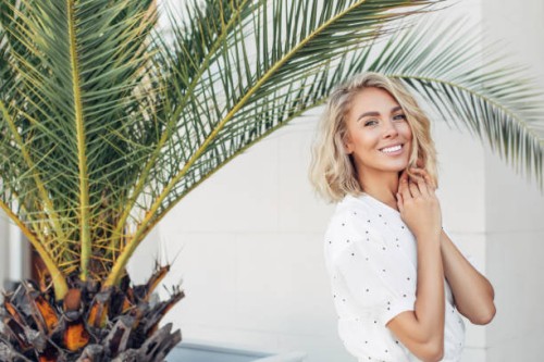 happy girl walking near palm trees on a summer sunny day - fashion stock pictures, royalty-free photos & images
