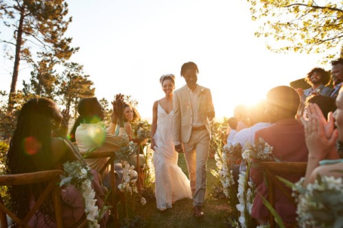 happy just married couple walking aisle amidst guests - garden decoration stock pictures, royalty-free photos & images