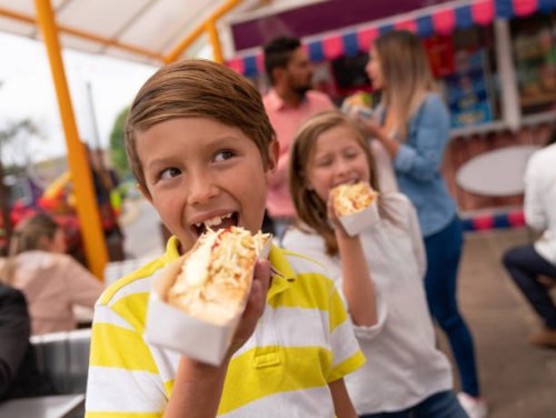 happy kids eating junk food at an amusement park - food stock pictures, royalty-free photos & images