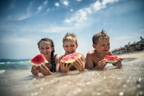 happy kids eating watermelon on the beach - food stock pictures, royalty-free photos & images