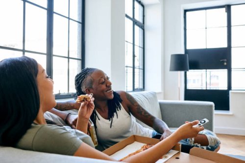 happy lesbian couple watching tv - junk food stock pictures, royalty-free photos & images