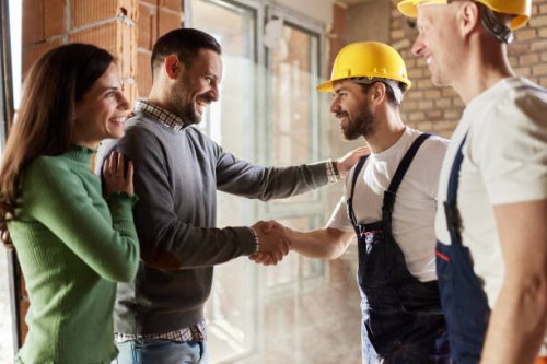 happy manual workers came to an agreement with a couple at construction site. - home decoration stock pictures, royalty-free photos & images