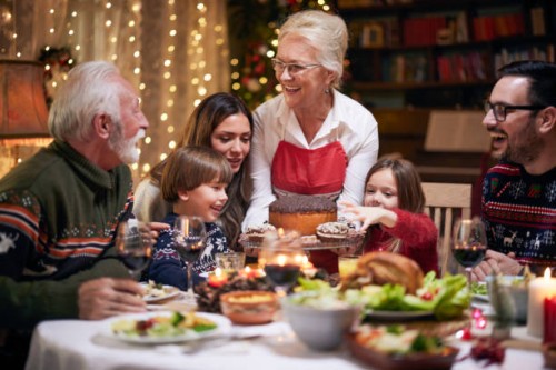 happy mature woman serving dessert to her family after christmas dinner. - food stock pictures, royalty-free photos & images