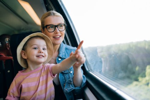 happy mother and daughter having fun while riding on the train together - travel stock pictures, royalty-free photos & images