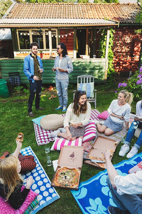 happy multi-ethnic friends having pizza in lawn during summer party - junk food stock pictures, royalty-free photos & images