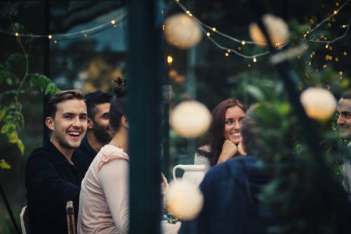 happy multi-ethnic young friends sitting at dining table during party in back yard - garden decoration stock pictures, royalty-free photos & images