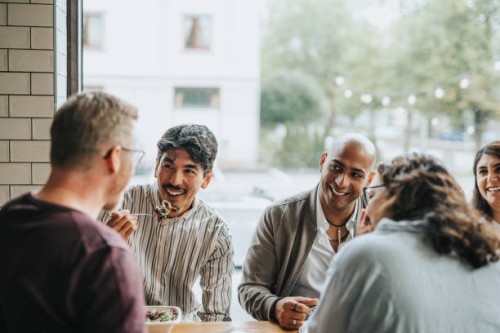 happy multiracial male and female colleagues having lunch together in restaurant - food stock pictures, royalty-free photos & images