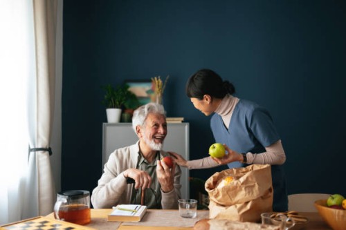 happy nurse delivering groceries to senior man at his home - food stock pictures, royalty-free photos & images