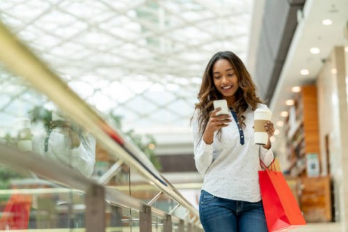 happy shopping woman texting on her cell phone - junk food stock pictures, royalty-free photos & images