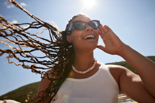 happy woman adjusting sunglasses on sunny day - hairstyle photos et images de collection