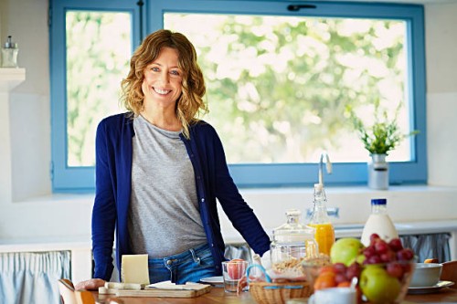 happy woman at breakfast table in kitchen - food stock pictures, royalty-free photos & images