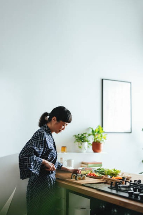 happy woman cutting sushi rolls in the kitchen - home decoration stock pictures, royalty-free photos & images