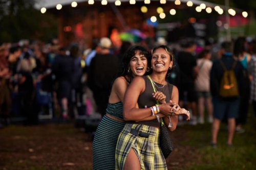 happy woman embracing female friend at concert - concert stock pictures, royalty-free photos & images