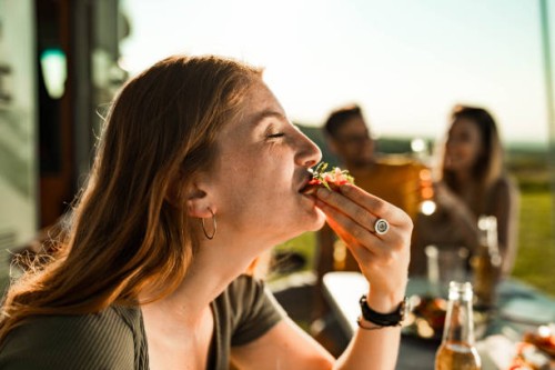 happy woman enjoying in sandwich during camping with her friends. - food stock pictures, royalty-free photos & images
