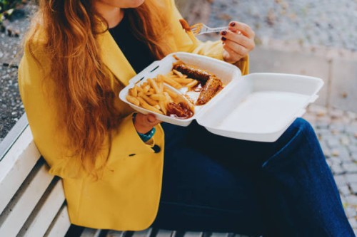 happy woman enjoying outdoor takeaway meal - junk food stock pictures, royalty-free photos & images