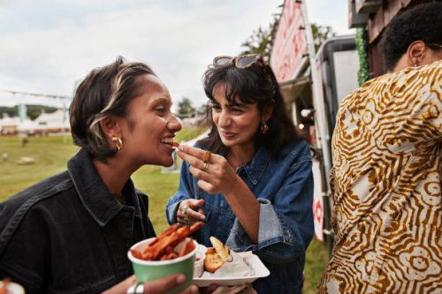 happy woman feeding female friend - food stock pictures, royalty-free photos & images