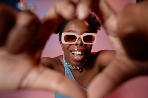 happy woman gesturing heart shape with fingers - fashion stock pictures, royalty-free photos & images