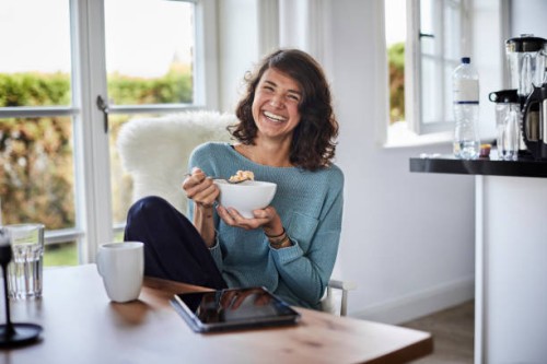 happy woman having breakfast at dining table - food stock pictures, royalty-free photos & images