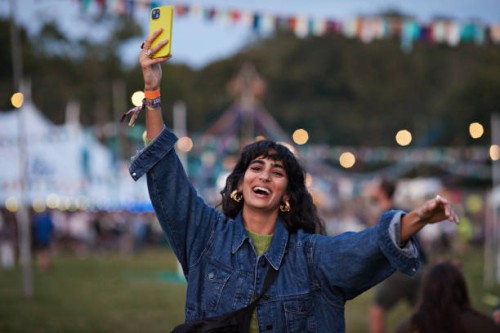 happy woman photographing through phone while dancing - concert stock pictures, royalty-free photos & images