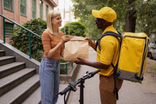 happy woman receiving her order from black delivery guy. - junk food stock pictures, royalty-free photos & images