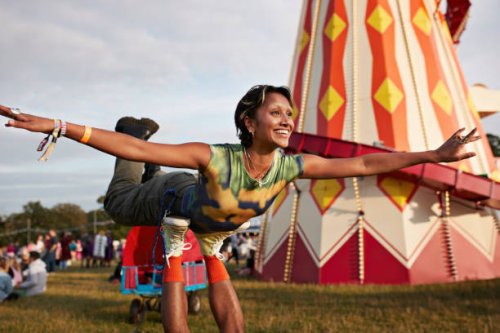 happy woman with arms outstretched balancing on legs - concert stock pictures, royalty-free photos & images