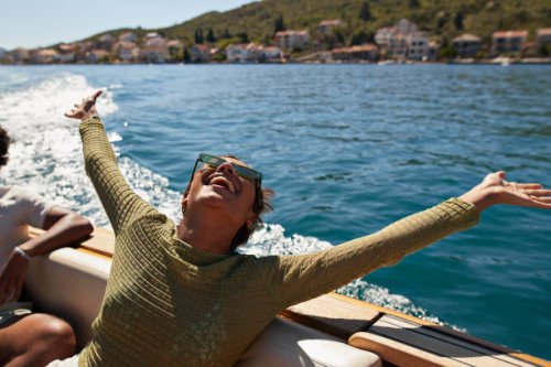 happy woman with arms raised in motorboat - travel stock pictures, royalty-free photos & images