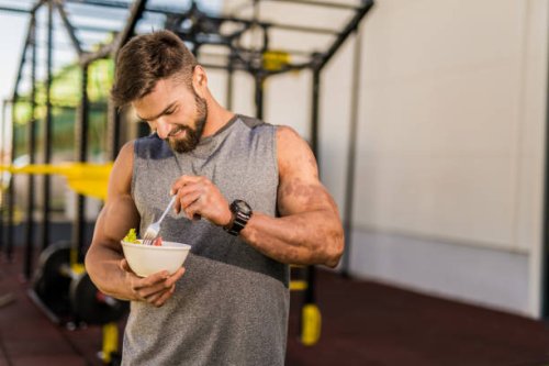 happy young bodybuilder eating a vegetable salad. - food stock pictures, royalty-free photos & images